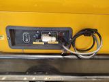 the back end of a yellow truck with wires attached to it
