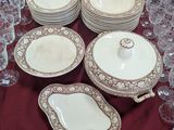 many plates and glasses on a table with a red table cloth