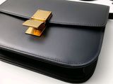 a black purse with a gold clasp on it