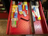 un tiroir rouge rempli de différents types de stylos et de crayons