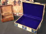 a small wooden box with a blue lid next to a small wooden box with a painting on it
