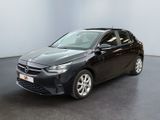 La Toyota Corollant est garée dans une pièce au sol noir.
