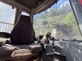 a seat in the back of a truck with a mountain view in the background