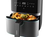 an air fryer with vegetables in it on a white background