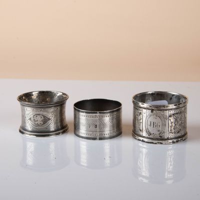 three silver napkins sitting on top of a table next to each other
