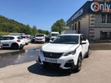 l'avant d'une voiture blanche garée devant un immeuble