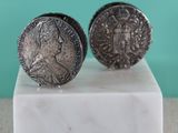 pair of silver coin cufflinks on a marble base