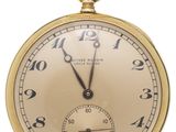 une vieille montre de poche en or avec des chiffres romains et des chiffres romains sur le cadran
