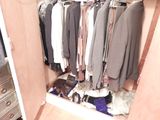 a closet with a lot of clothes hanging on it