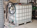un grand conteneur muni d'un tuyau, dans un garage