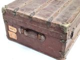 an old suitcase sitting on a table with a tag on it