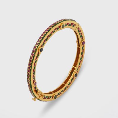 un gros plan sur un bracelet en or orné de pierres multicolores