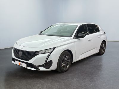 Une voiture blanche est garée dans une pièce blanche au sol noir.