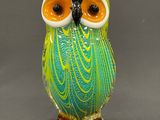 une figurine de chouette en verre posée sur une table