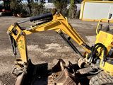 a yellow excavator that is sitting in the dirt