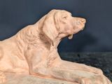 a statue of a dog that is laying down