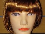 un gros plan sur la tête d'un mannequin avec du rouge à lèvres orange