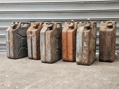 cinq vieux bidons d'essence alignés les uns à côté des autres
