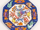 an image of a blue and orange plate with birds and flowers on it