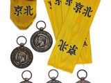 four medals and a gold ribbon with chinese characters on them