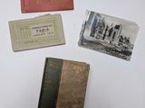 Plusieurs vieux livres sont posés sur une surface blanche