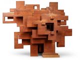 a sculpture made of wooden blocks on a white surface