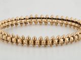 un gros plan sur un bracelet en or orné de pointes