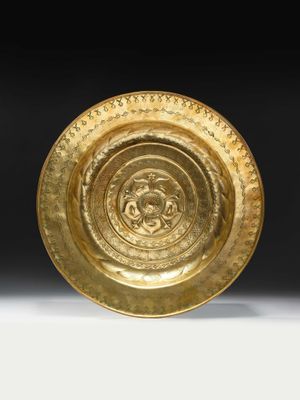 a close up of a gold plate on a white surface