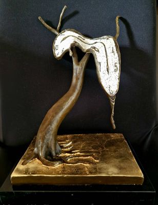 a bronze sculpture of a tree with a bird on it