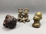three bronze figurines of a woman and a man sitting next to each other