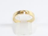 a close up of a gold ring on a white surface