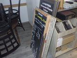 un tableau noir sur lequel est inscrit un menu, à côté d'une chaise