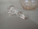 a clear glass object sitting on a table next to a bowl