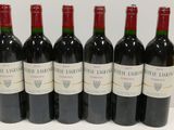 six bottles of red wine lined up in a row on a table