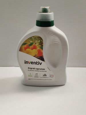 une bouteille de liquide posée sur une table à côté d'une autre bouteille de liquide