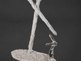 une photo représentant une sculpture d'une personne à skis posée sur un socle en bois