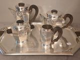 a silver tray with a silver tea set on it