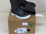 une paire de bottes de pluie noires posée sur une boîte en carton