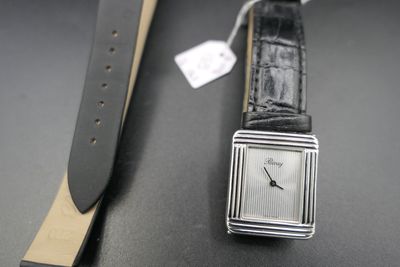 a watch that is sitting on a table next to a watch strap