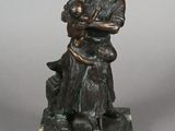 statue en bronze représentant un homme tenant un bébé et un chien, posée sur un socle en marbre