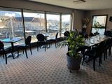 tables and chairs in a large room with a view of a city