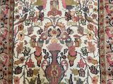 an antique persian rug with a floral design on a white ground