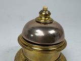 a silver and gold bell sitting on top of a white table