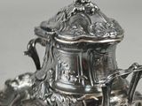a silver plate with a silver teapot on it