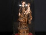 statue représentant une femme et un enfant, posée sur une table et recouverte d'un dôme en verre