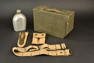 une boîte, une bouteille et une paire de ciseaux posés sur une table