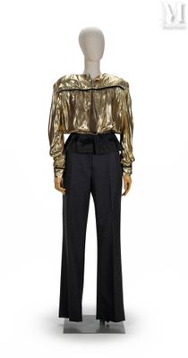 Le mannequin porte un haut doré et un pantalon noir.
