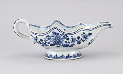 un vieux bol bleu et blanc avec une anse, posé sur une table