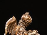 an image of a bronze statue of a winged animal on a table