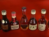several bottles of liquor are lined up on a red surface